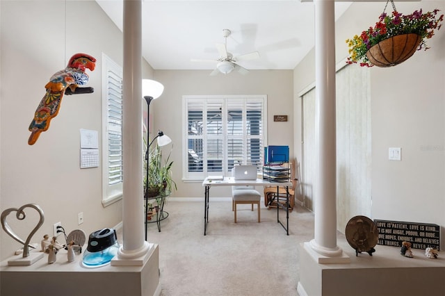 home office with decorative columns, ceiling fan, and light carpet