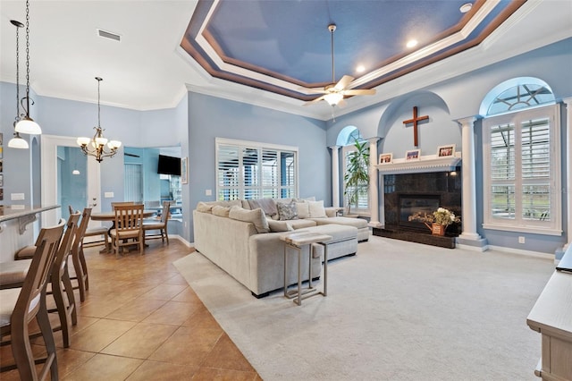 living room featuring a premium fireplace, decorative columns, light tile patterned floors, and a raised ceiling