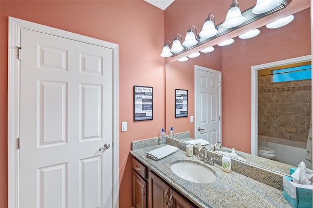 bathroom with a washtub, toilet, and vanity