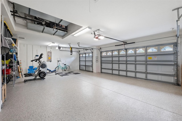 garage with a garage door opener and electric panel