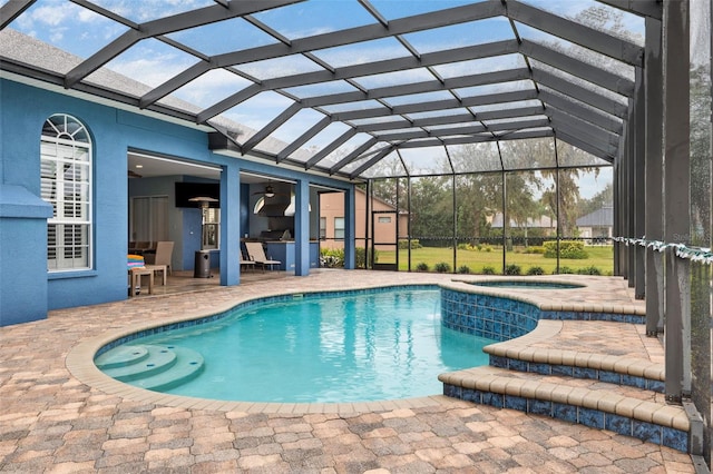 view of swimming pool featuring an in ground hot tub, glass enclosure, and a patio area