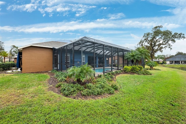 rear view of property with a lanai and a yard