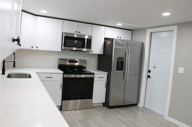 8703 Robilina Rd, Port Richey, FL 34668 - kitchen featuring sink, white cabinets, stainless steel appliances, and tasteful backsplash