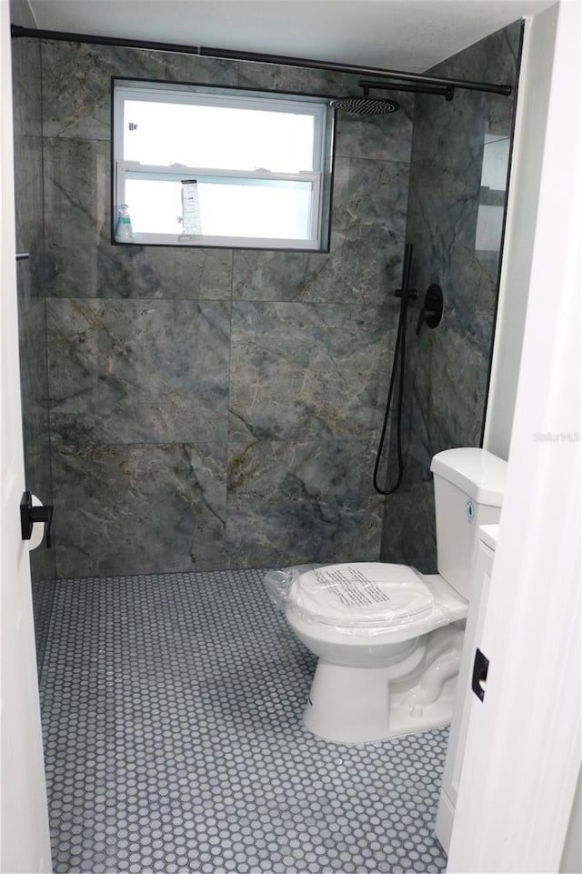 8703 Robilina Rd, Port Richey, FL 34668 - bathroom with tiled shower, toilet, and tile patterned flooring