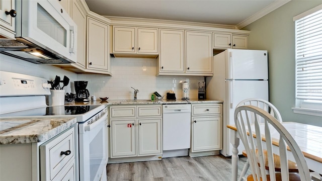 kitchen featuring crown molding, white appliances, a healthy amount of sunlight, and light hardwood / wood-style floors