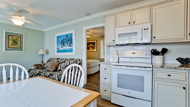 kitchen with cream cabinets, white appliances, crown molding, and tasteful backsplash