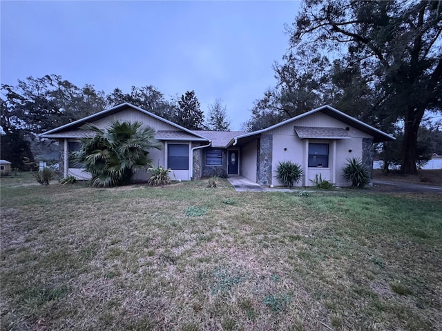 single story home featuring a front lawn