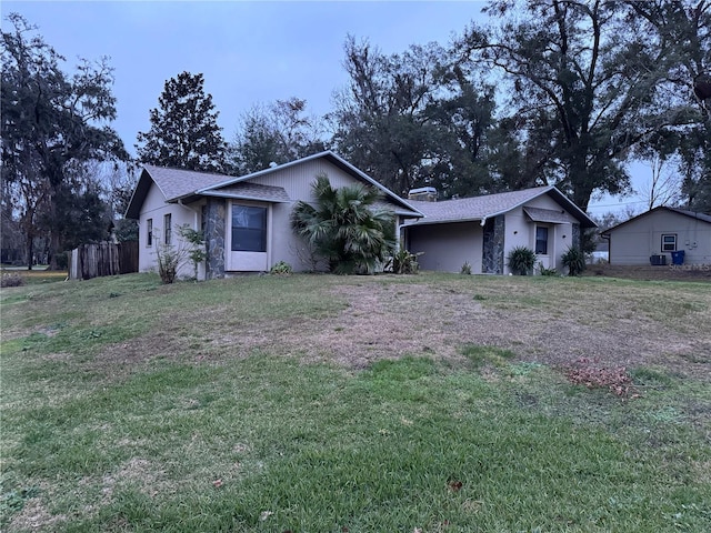 ranch-style house featuring central AC unit and a front lawn