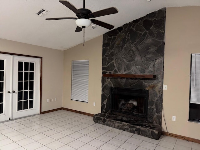 unfurnished living room featuring vaulted ceiling, ceiling fan, french doors, a fireplace, and light tile patterned flooring