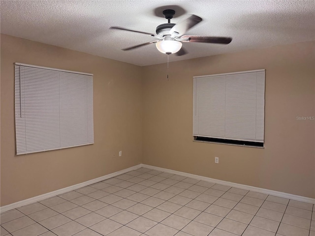 tiled empty room featuring a textured ceiling and ceiling fan