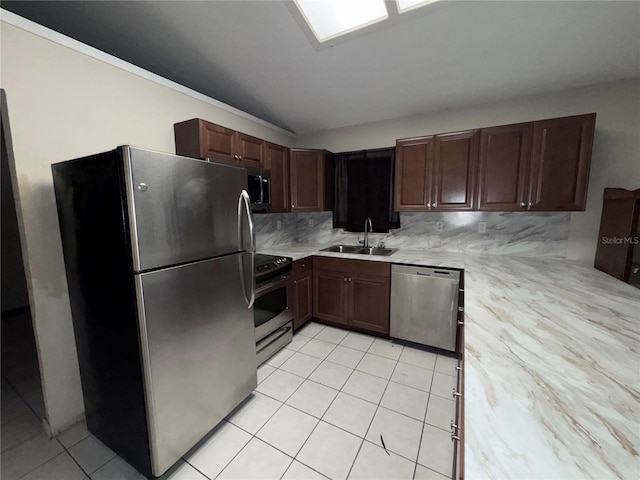 kitchen featuring appliances with stainless steel finishes, tasteful backsplash, light tile patterned floors, sink, and dark brown cabinetry