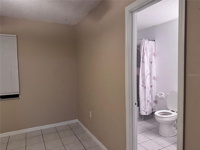 bathroom featuring toilet, a textured ceiling, tile patterned floors, and a shower with shower curtain