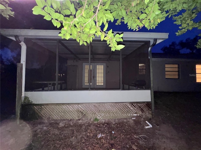 view of side of property with french doors and a lanai