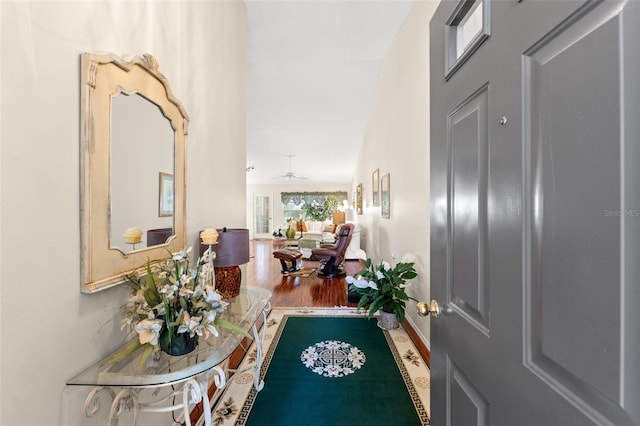 hall featuring lofted ceiling and hardwood / wood-style floors