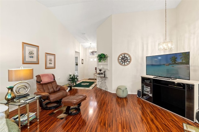 living room with hardwood / wood-style flooring, a chandelier, and vaulted ceiling