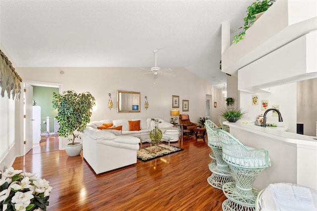 living room with lofted ceiling, wood-type flooring, sink, and ceiling fan