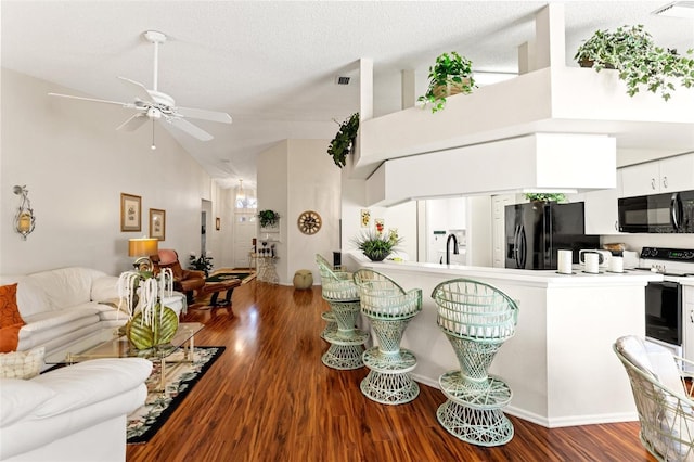 kitchen featuring white cabinetry, dark hardwood / wood-style floors, a textured ceiling, black appliances, and sink