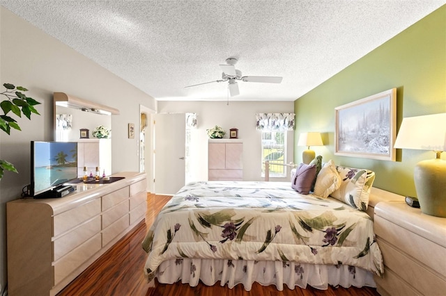 bedroom featuring ceiling fan, dark wood-type flooring, and a textured ceiling