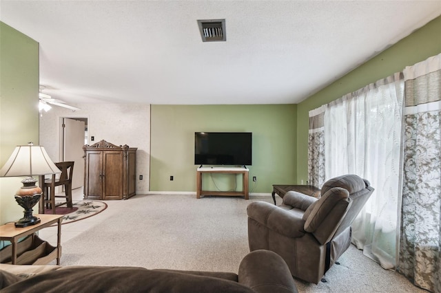 living room with ceiling fan, a textured ceiling, and light tile patterned flooring