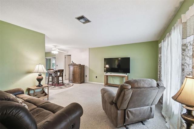 carpeted living room with ceiling fan and a textured ceiling