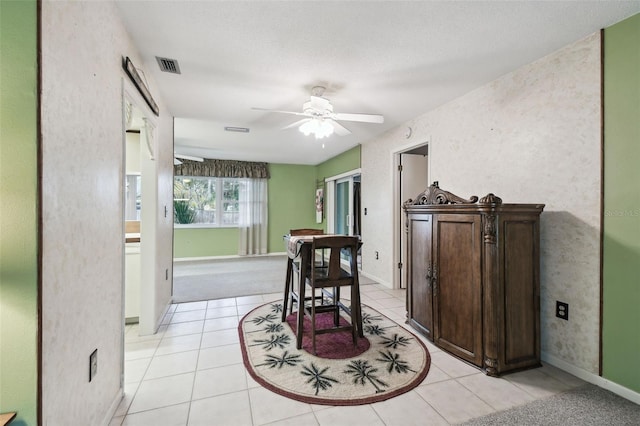 dining area featuring ceiling fan, light tile patterned floors, and a textured ceiling