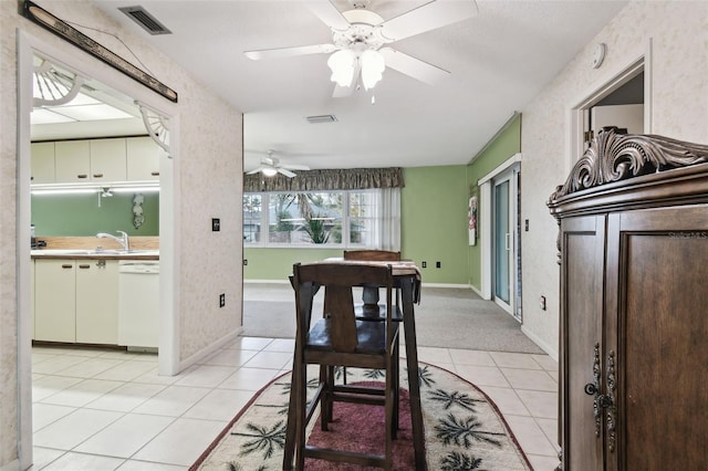 tiled dining area with ceiling fan and sink