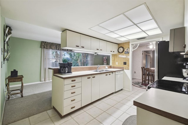 kitchen featuring light colored carpet, dishwasher, white cabinets, and sink