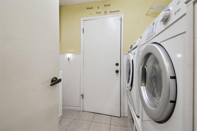 washroom featuring washer and clothes dryer and light tile patterned floors