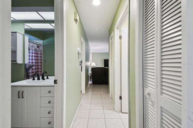 hallway featuring light tile patterned floors and sink