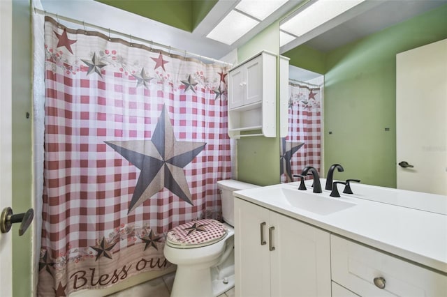 bathroom with toilet, vanity, and tile patterned floors