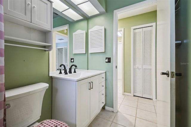 bathroom featuring toilet, tile patterned flooring, and vanity