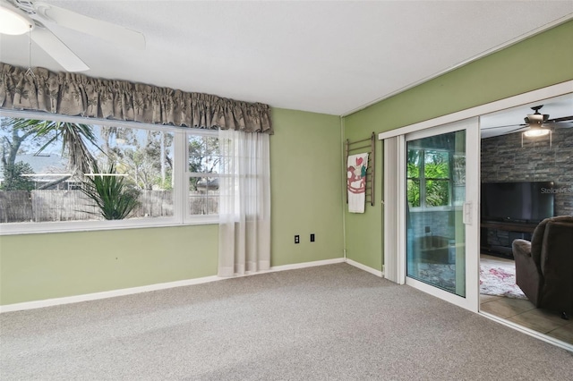 unfurnished room with carpet floors, ceiling fan, and a wealth of natural light