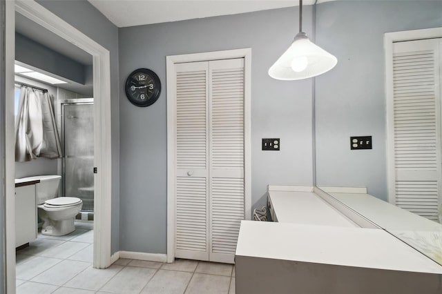 bathroom with toilet, tile patterned flooring, a shower with shower door, and vanity