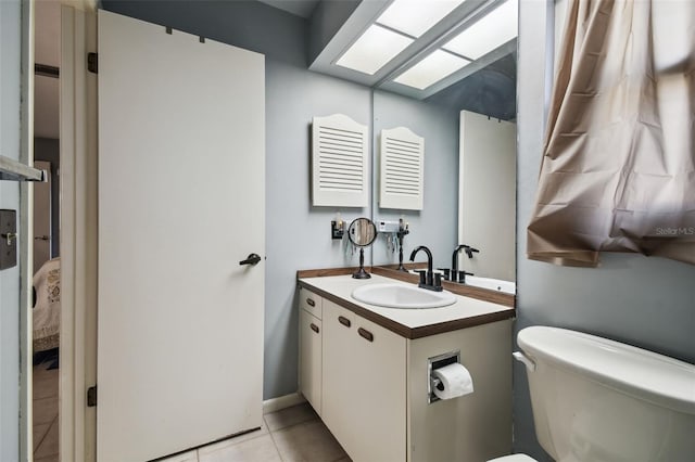 bathroom featuring toilet, tile patterned floors, and vanity