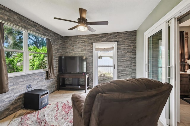 tiled living room featuring ceiling fan and a wealth of natural light