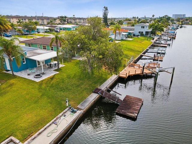 view of dock with a water view, a yard, and a patio