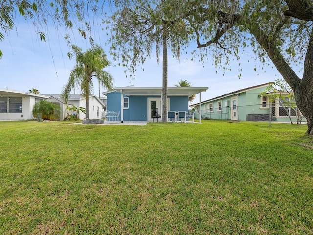 back of house featuring a patio area and a lawn