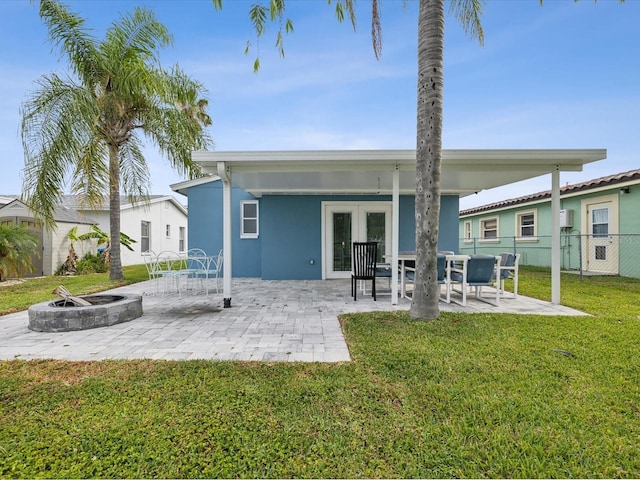 rear view of property featuring a yard, french doors, and a patio