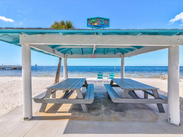 view of patio / terrace with a water view, a gazebo, and a beach view