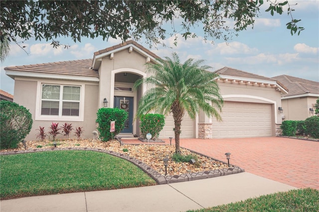 mediterranean / spanish-style home with a garage and a front lawn