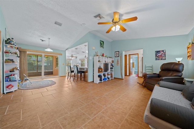 living room featuring lofted ceiling, light tile patterned floors, a textured ceiling, and ceiling fan