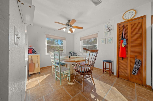 dining space with ceiling fan and a textured ceiling