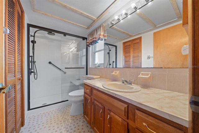 bathroom featuring toilet, vanity, decorative backsplash, and walk in shower