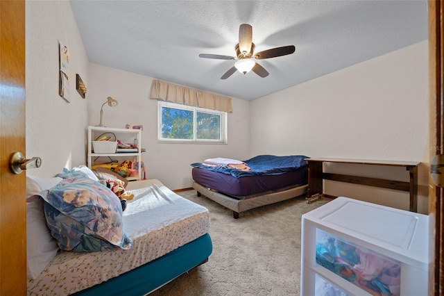 carpeted bedroom featuring ceiling fan and a textured ceiling