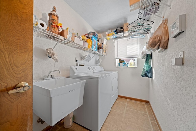 laundry room featuring sink, washing machine and dryer, and a textured ceiling