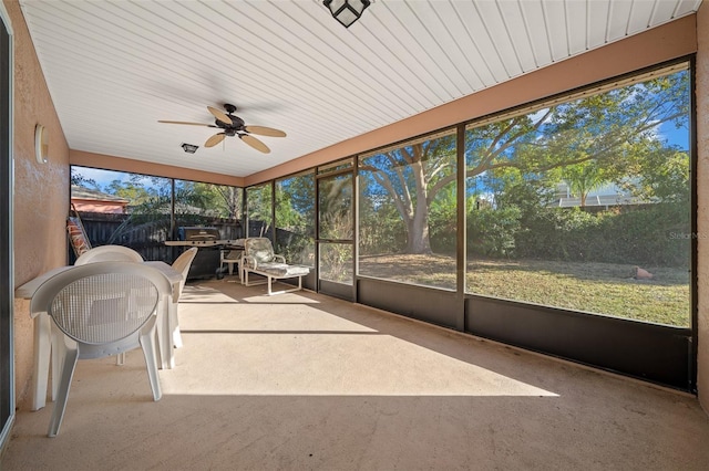 unfurnished sunroom featuring ceiling fan