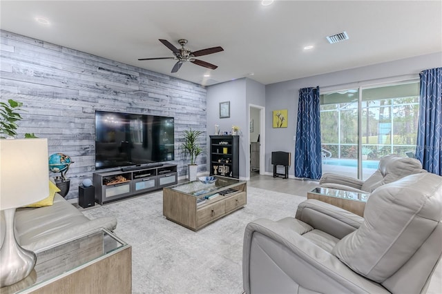 living room featuring ceiling fan and wood walls