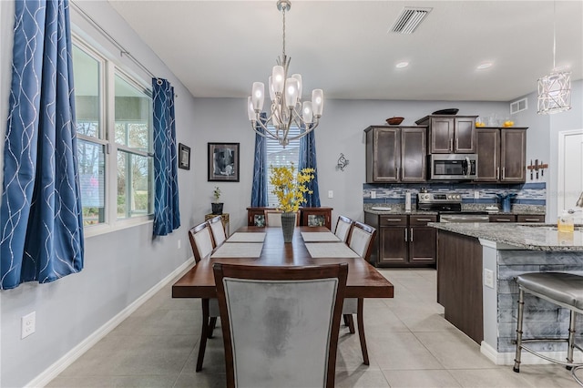 tiled dining space with sink and a chandelier