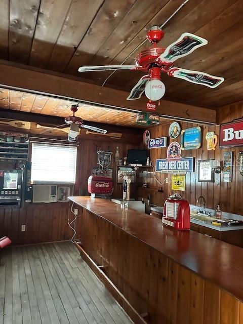 interior space with ceiling fan, wooden walls, hardwood / wood-style floors, and wooden ceiling