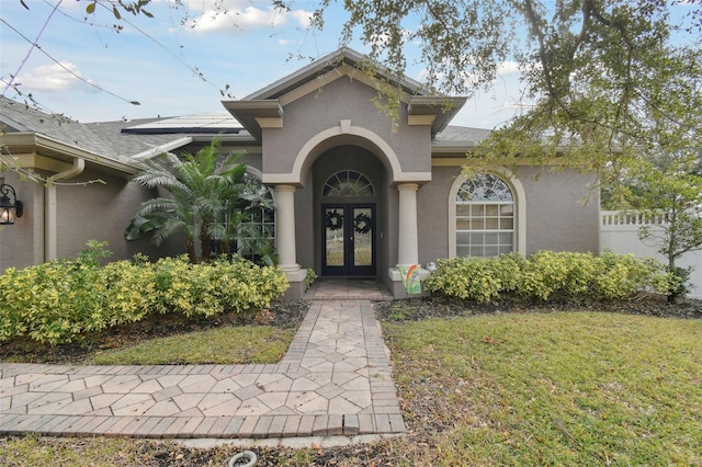 entrance to property featuring french doors and a yard